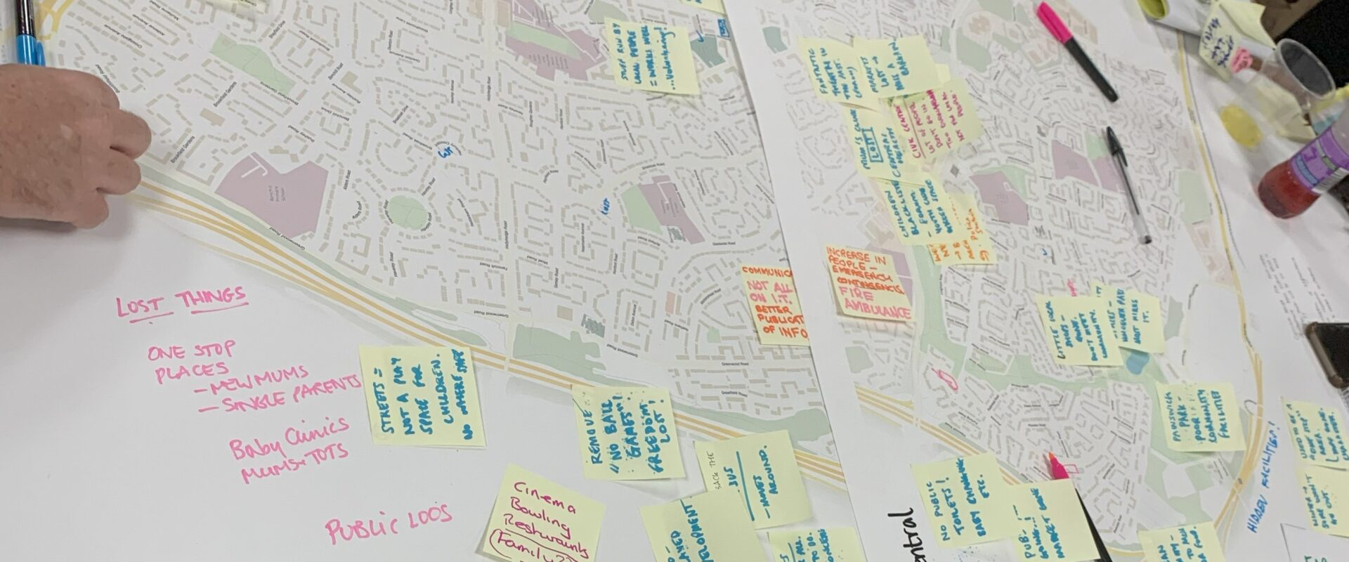 People putting post it notes on a map of a neighbourhood