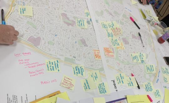 People putting post it notes on a map of a neighbourhood